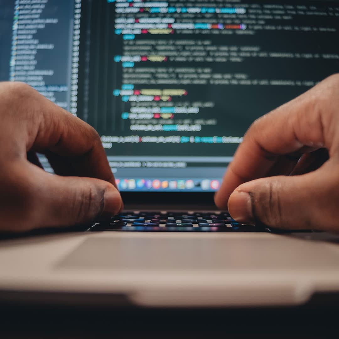 computadora y manos de una persona programando